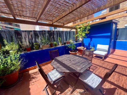 a patio with a table and chairs and potted plants at Casa a 20 minuts de Barcelona in Molins de Rei