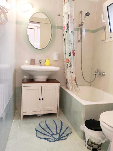 a bathroom with a sink and a toilet and a mirror at Twins home in Ierapetra