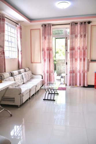 a living room with a couch and a large window at Xuan Luom Guesthouse in Phan Thiet