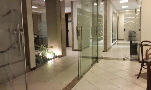 an empty lobby with glass doors in a building at Portal da Princesa Hotel in Feira de Santana