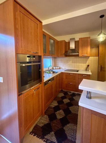 a kitchen with wooden cabinets and a sink and a stove at Cozy Home in Peje