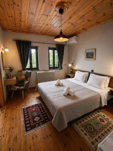 ein Schlafzimmer mit einem großen Bett und einer Holzdecke in der Unterkunft Vikos View in Aristi