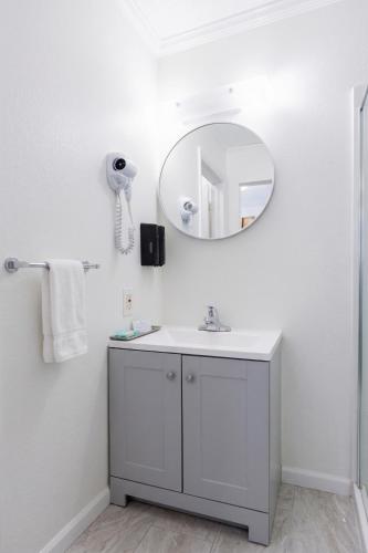 a white bathroom with a sink and a mirror at Blue Heron Motel in Nags Head