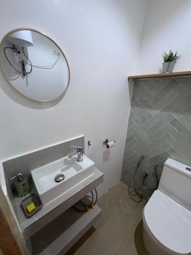 a bathroom with a white sink and a mirror at Keur Noflaye Ngaparou in Mbour
