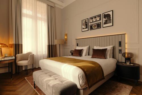 a hotel room with a large bed and a chair at The Manor Amsterdam in Amsterdam