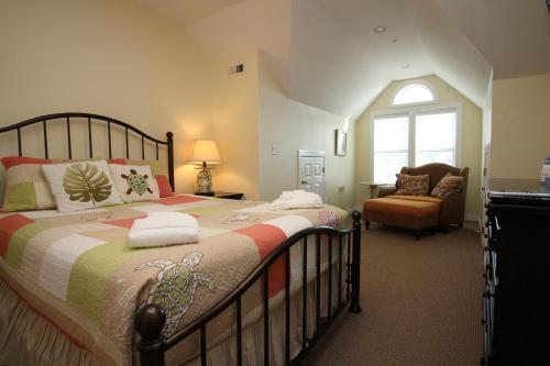 a bedroom with a large bed and a chair at Cambridge Cove at Bermuda Bay by Kees Vacations in Kill Devil Hills
