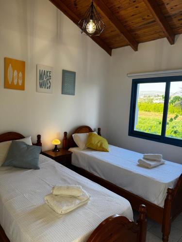 two beds in a room with a window at KOHILI Seaside Residence in Polis Chrysochous