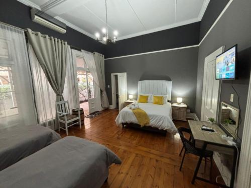 una camera da letto con due letti, una scrivania e una TV di Bright Diamond Inn a Kimberley