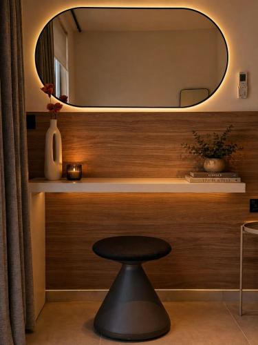 a black stool in a room with a mirror at Exclusive Retreat off the Sea Front Promenade in Il-Gżira