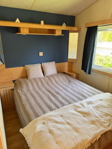 a bedroom with a bed and a window at Camping paradis in Clohars-Carnoët
