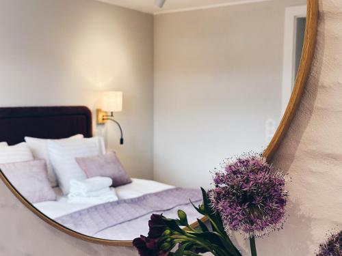 a bedroom with a mirror next to a bed at ToRUŃ ApartHotel z widokiem na Wisłę i Krzywą Wieżę in Toruń