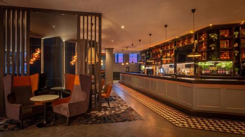a bar in a restaurant with chairs and a counter at Clayton Hotel, Leeds in Leeds