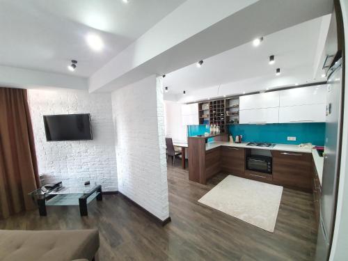 a kitchen and living room with a couch and a tv at Hotel Ismail in Chişinău