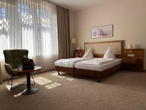 a bedroom with a bed and a chair and a table at Boardinghouse am Wall in Salzgitter-Bad
