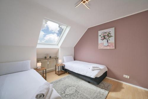a small bedroom with two beds and a window at SANO - Hagen - Hegel in Hagen