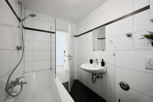 a white bathroom with a shower and a sink at SANO - Hagen - Hegel in Hagen