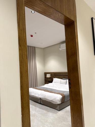 a bedroom with a bed and a mirror at مسكن ترف للشقق الفندقية in Al Majma'ah