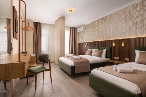 a hotel room with two beds and a desk at Taksim Peradise Hotel in Istanbul