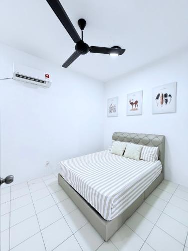 a white bedroom with a bed and a ceiling fan at Nj Guesthouse in Tawau