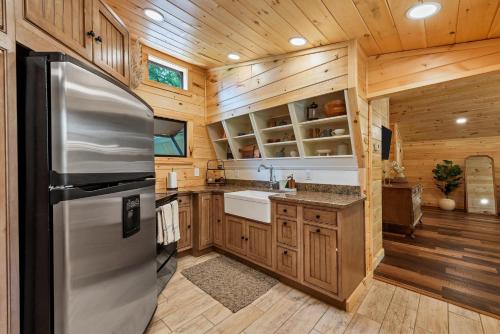 a kitchen with a stainless steel refrigerator and wooden cabinets at Riverside in Townsend