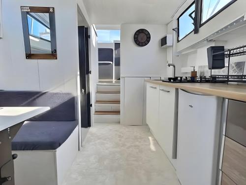 a kitchen with white cabinets and a clock on the wall at The Blue Boat in Valence