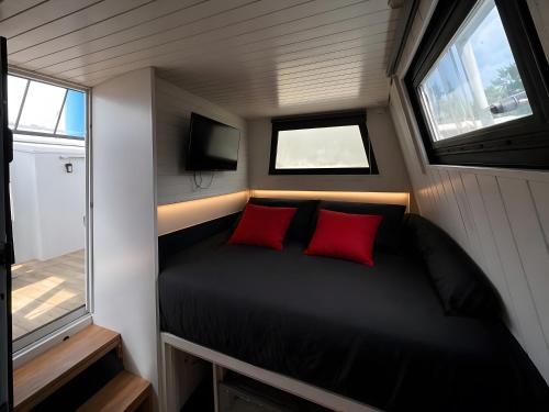 a small bedroom with a bed with two red pillows at The Blue Boat in Valence