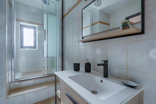 a white bathroom with a sink and a mirror at L'escarpin - Billiards - Historic in Romans-sur-Isère