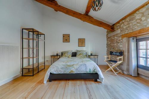 a bedroom with a bed and a stone wall at L'escarpin - Billiards - Historic in Romans-sur-Isère