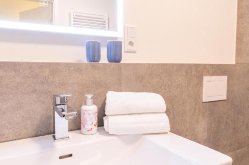 a bathroom with a sink and a mirror and towels at Hyggehuus Tossens - Küste33 41 in Tossens