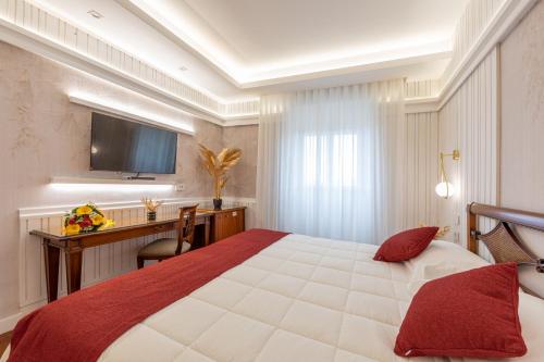 a hotel room with a large bed and a desk at Hotel&Ristorante Miramonti Palazzo Storico in Rieti