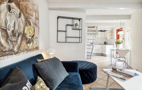 a living room with a blue couch and a kitchen at 1 Bedroom Cozy Apartment In Gilleleje in Gilleleje