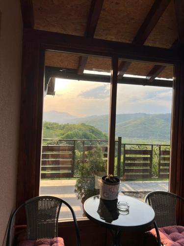 a table and chairs in front of a large window at Apartman Sofiana in Bajina Bašta
