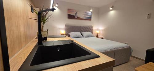 a bathroom with a sink and a bed in a room at Lighthouse Zadar Center Apartments in Zadar