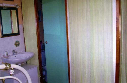 La salle de bains est pourvue d'un lavabo et d'une porte bleue. dans l'établissement Chambre chez Corinne, à Fourneville