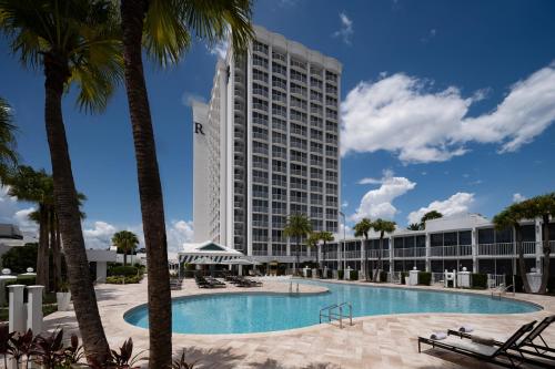 a hotel with a swimming pool and palm trees at Renaissance Orlando Resort - Disney Springs Area - Free Shuttle & Early Entry to Disney Theme Parks in Orlando