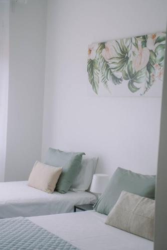 two beds in a room with flowers on the wall at Just Like Home - Retorta do Pico in Caminha