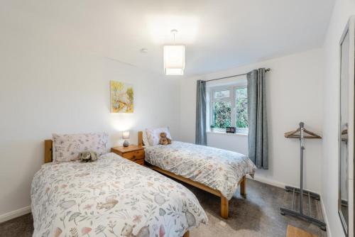 a bedroom with two beds and a window at 2 Bed in Berrynarbor oc-l34468 in Berrynarbor
