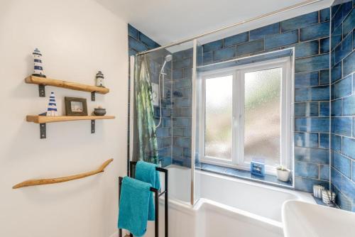 a bathroom with a window and blue tiles at 2 Bed in Berrynarbor oc-l34468 in Berrynarbor