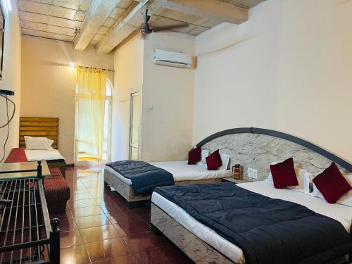 a bedroom with two beds in a room at The Wayside Inn in Matheran