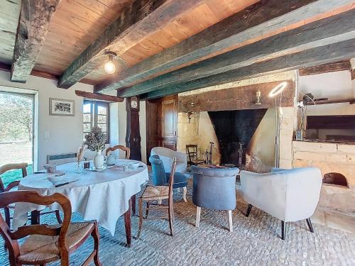 a dining room with a table and a fireplace at Holiday Home Le Petit Gîte by Interhome in Jayac