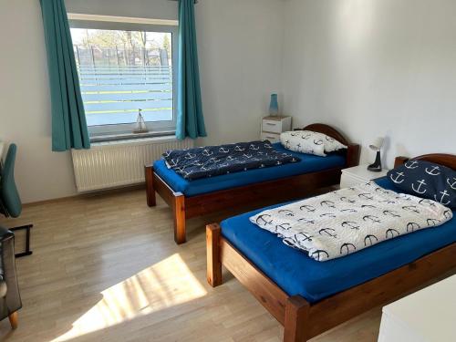 two beds in a room with a window at Break in Kudensee