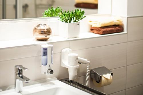 a bathroom with a sink with a hair dryer at Hotel Sonnengarten in Sommerhausen
