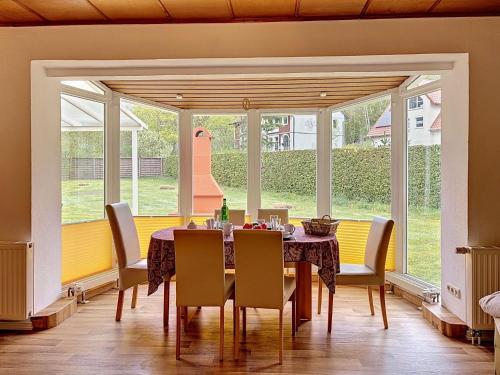 a dining room with a table and chairs and a large window at Holiday Home Alexorella by Interhome in Godern