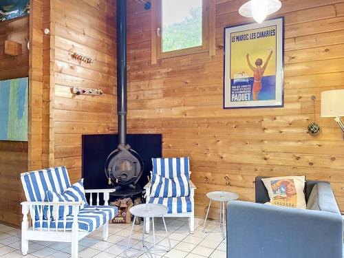 a living room with a wood paneled wall with a stove at Holiday Home L'Escouarte by Interhome in Maubuisson