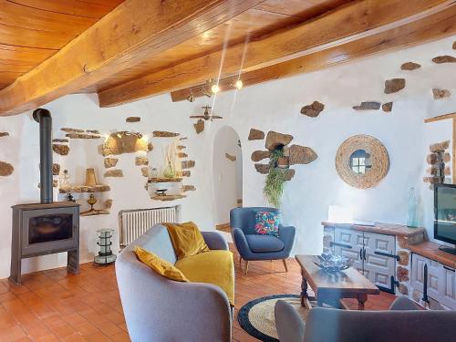 a living room with a couch and chairs and a television at Holiday Home Chez Canard by Interhome in Ampus