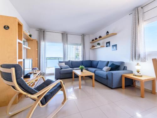 a living room with a blue couch and a table at Apartment Nou Salou-1 by Interhome in Salou