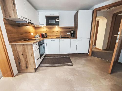 a kitchen with white cabinets and a sink at Apartment Haus Toferer by Interhome in Grossarl