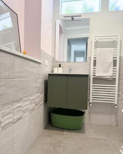 a bathroom with a green sink and a mirror at Dimora San Francesco in Sarzana
