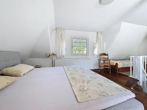 a white bedroom with a bed and a window at Holiday Home Moselhäuschen by Interhome in Traben-Trarbach