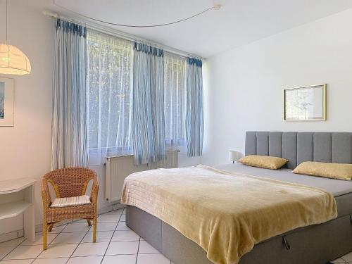 a bedroom with a bed and a chair and a window at Apartment Appartement A12 by Interhome in Traben-Trarbach